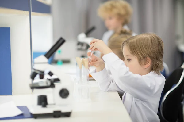 Boy adjusting test tubes — Stock Photo, Image