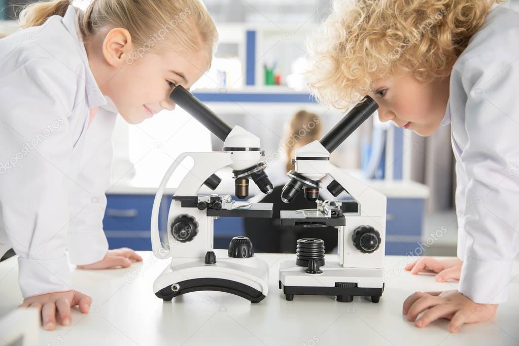 Schoolchildren using microscopes    