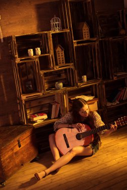 woman in boho style playing guitar 