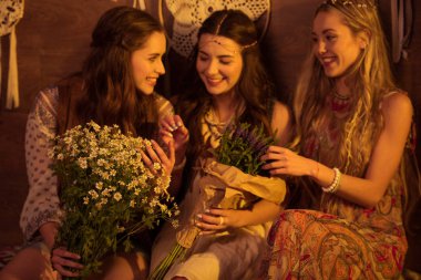 women in boho style posing with flowers 