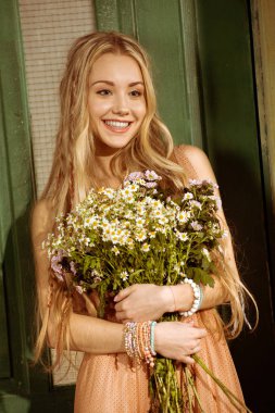 Young bohemian woman holding chamomiles