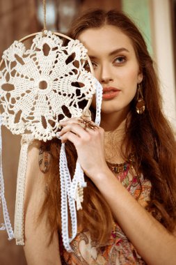 Young bohemian woman holding dreamcatcher clipart