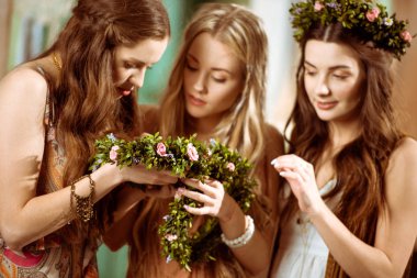 Bohemian women holding floral wreaths clipart