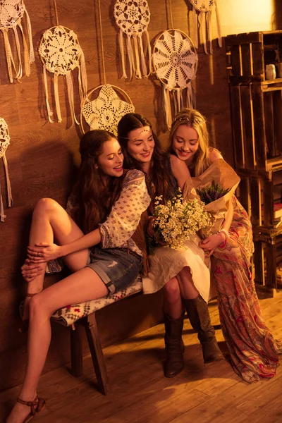 women in boho style sitting with flowers
