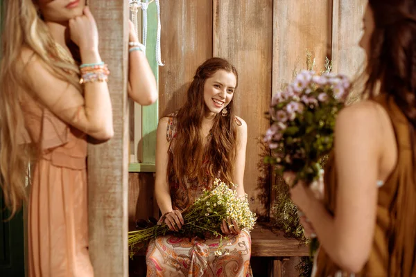 Jeunes femmes bohème tenant des fleurs — Photo