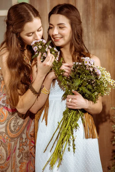Bohemian young women smelling flowers — Stock Photo, Image