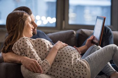 Young couple using digital tablet clipart