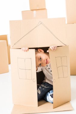 Boy sittling inside of cardboard box clipart