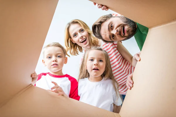 Rodina prohlížení z lepenkové krabice — Stock fotografie