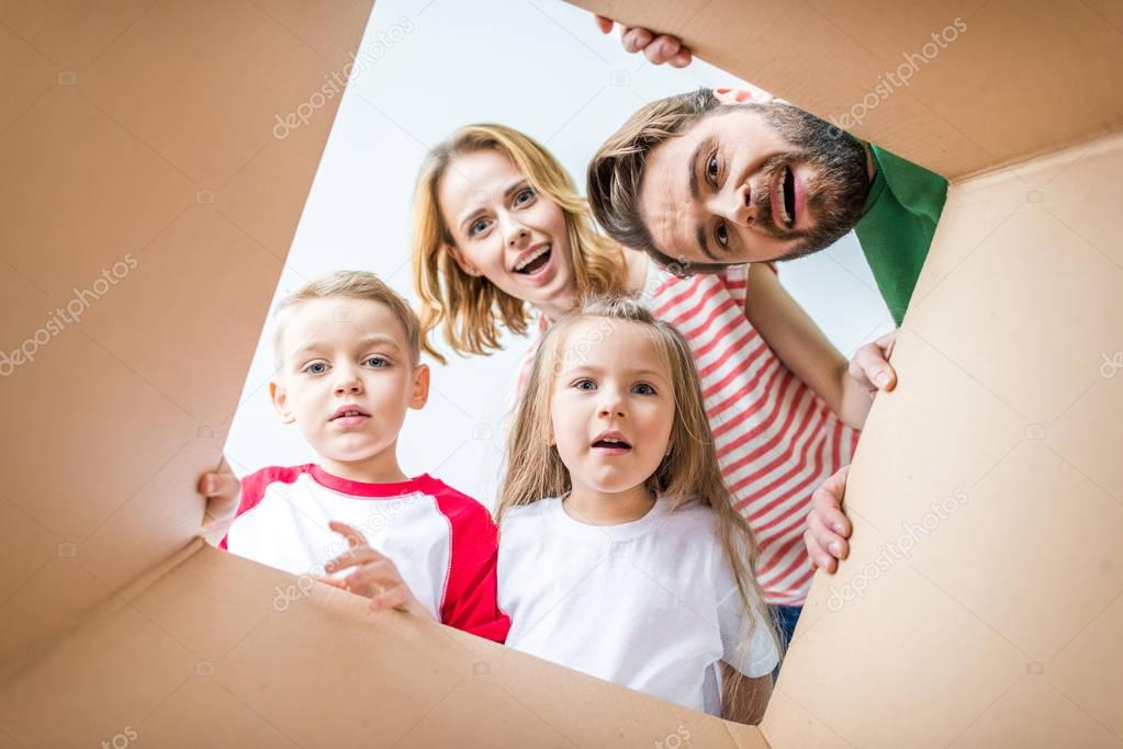 Family peeking from cardboard box