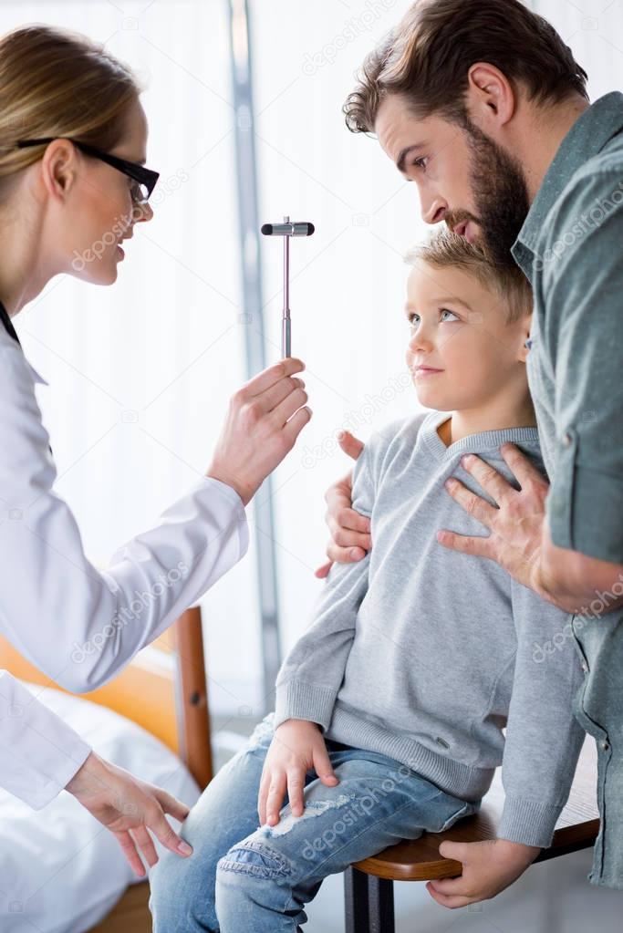 Doctor inspecting little boy