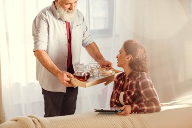 Adam holding tepsisi çayı ile  