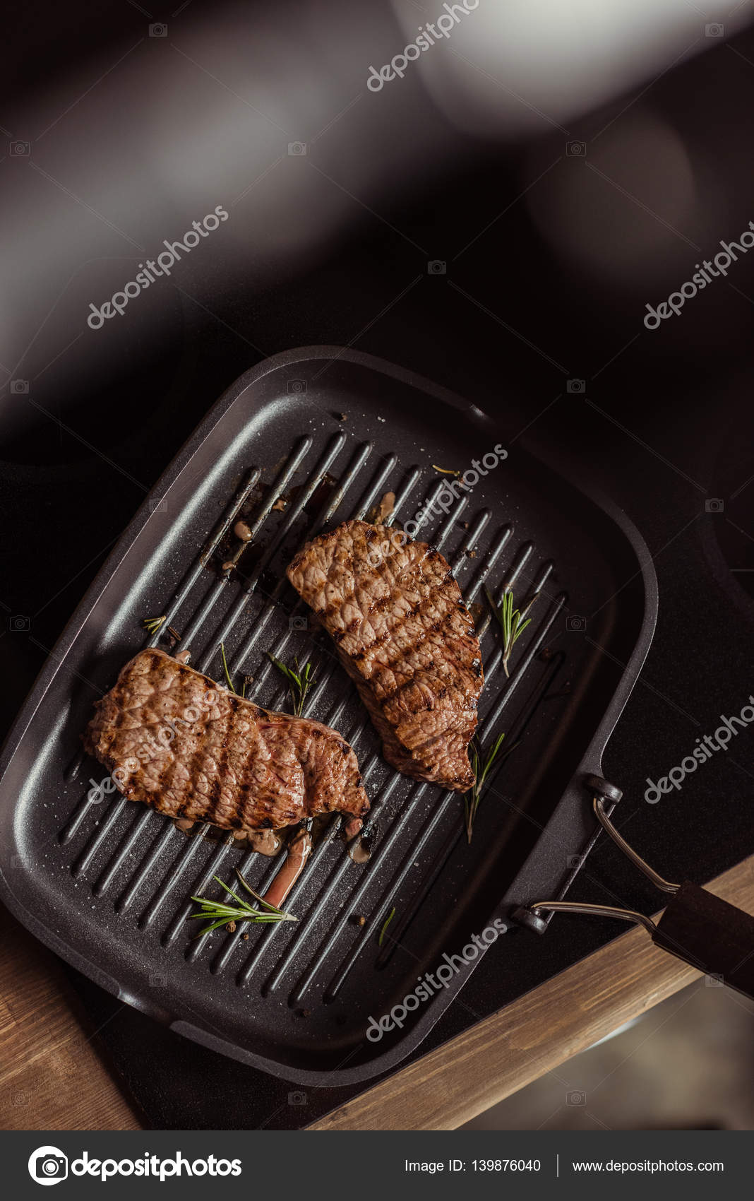 Grilled steaks in frying pan Stock Photo by ©ArturVerkhovetskiy 139876040