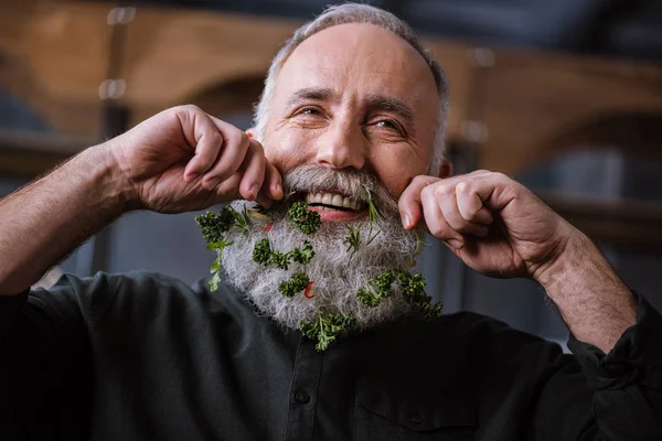 Senior man with greens in beard — Stock Photo, Image