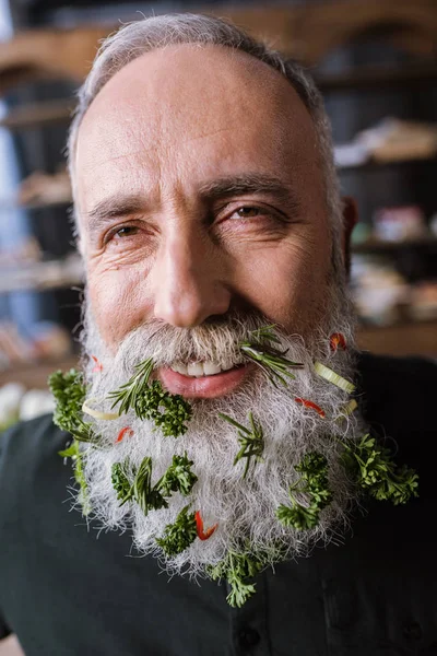 Senior man with greens in beard — Stock Photo, Image