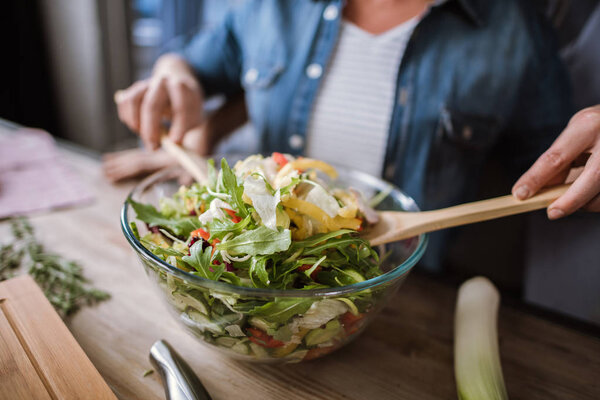 Couple cooking vegetable salad 