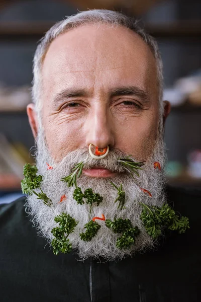 Senior man with greens in beard — Stock Photo, Image