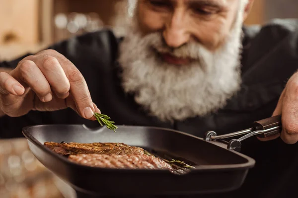 Homem cozinhando bifes — Fotografia de Stock