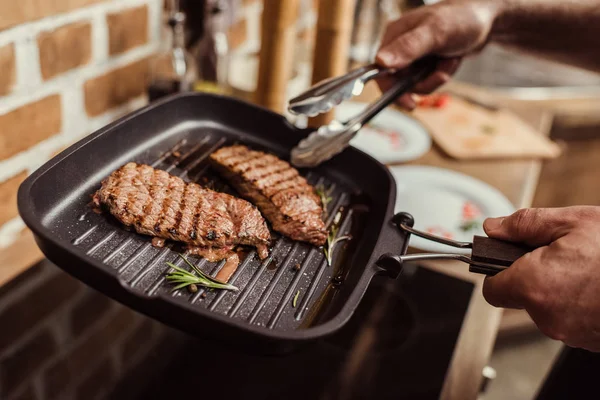 Uomo che cucina bistecche — Foto Stock