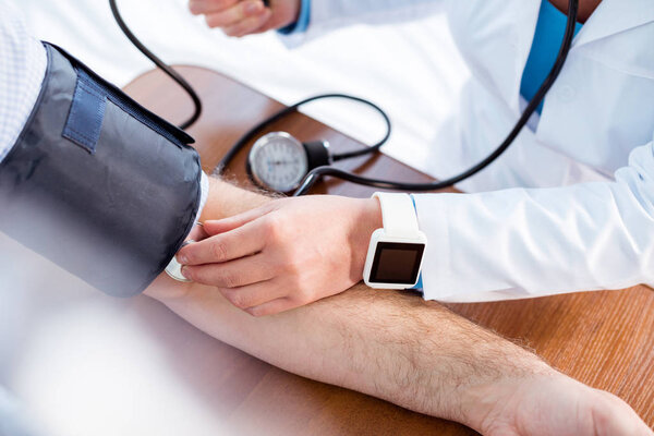 Doctor measuring pressure of patient