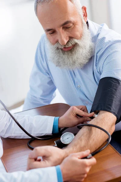 Médico que mede a pressão do paciente — Fotografia de Stock