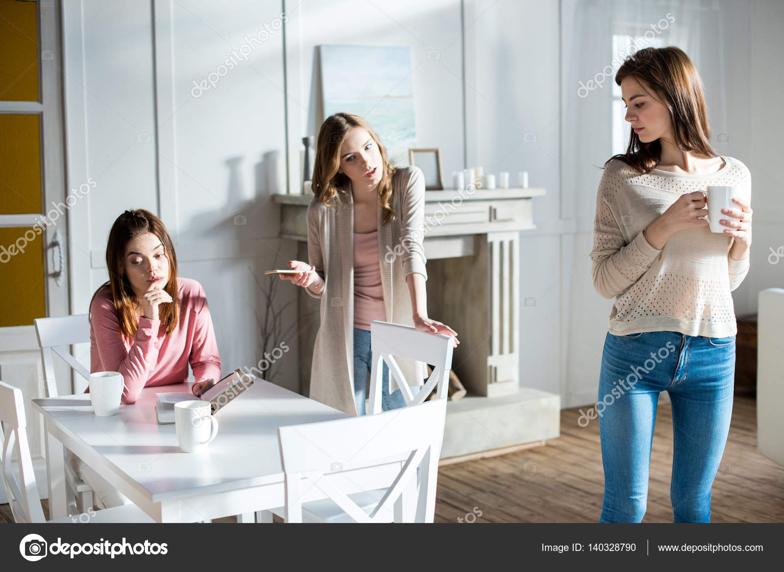 Giovani donne che litigano — Foto Stock © ArturVerkhovetskiy Tre giovani donne che litigano mentre beve il caff¨ a casa — Foto di ArturVerkhovetskiy