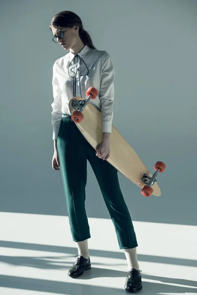 Hipster woman holding skateboard — Stockfoto