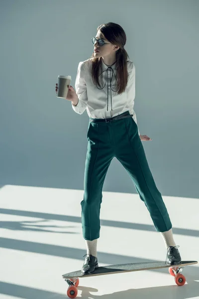 Hipster woman standing on skateboard — Stock Photo, Image