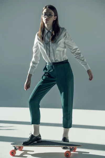 Hipster woman standing on skateboard