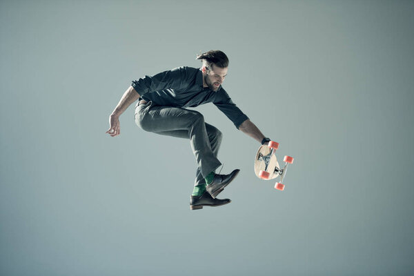 Стильный мужчина держит скейтборд
 