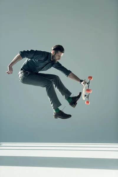 Fashionable man holding skateboard — Stock Photo, Image