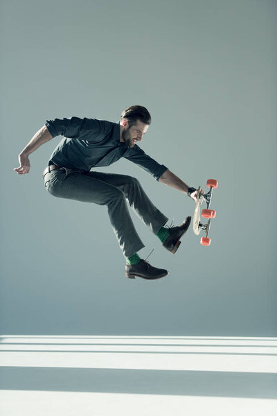 fashionable man holding skateboard 