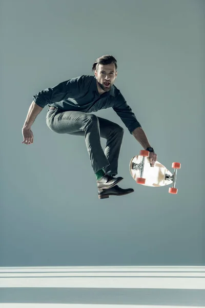 Fashionable man holding skateboard — Stockfoto