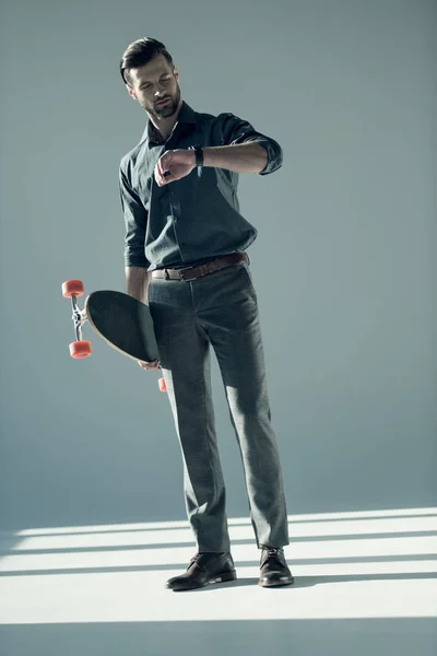 Homem elegante segurando skate — Fotografia de Stock