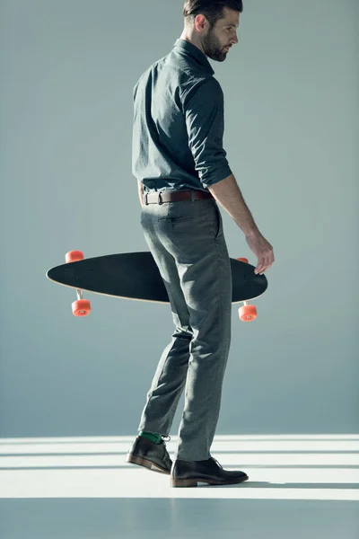 Eleganta mannen innehav skateboard — Stockfoto