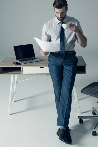 Hombre de negocios de pie por mesa — Foto de Stock