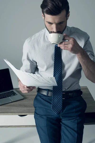 Hombre de negocios de pie por mesa —  Fotos de Stock