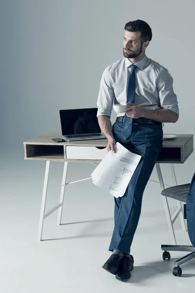 Hombre de negocios de pie por mesa —  Fotos de Stock