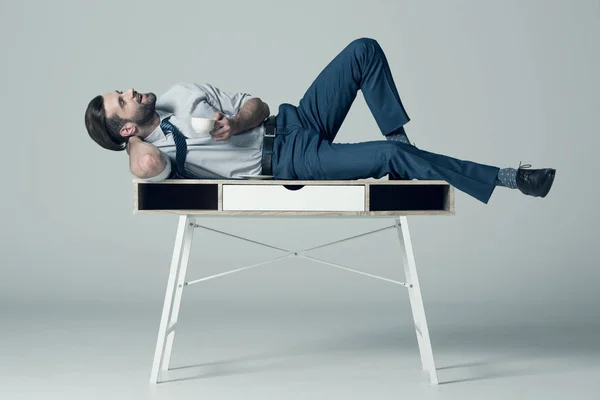 Affärsman liggande på bordet — Stockfoto