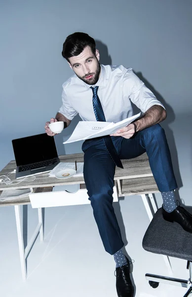 Businessman sitting on table — Stock Photo, Image