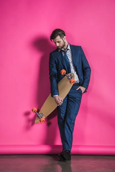 Uomo in tuta con skateboard — Foto Stock