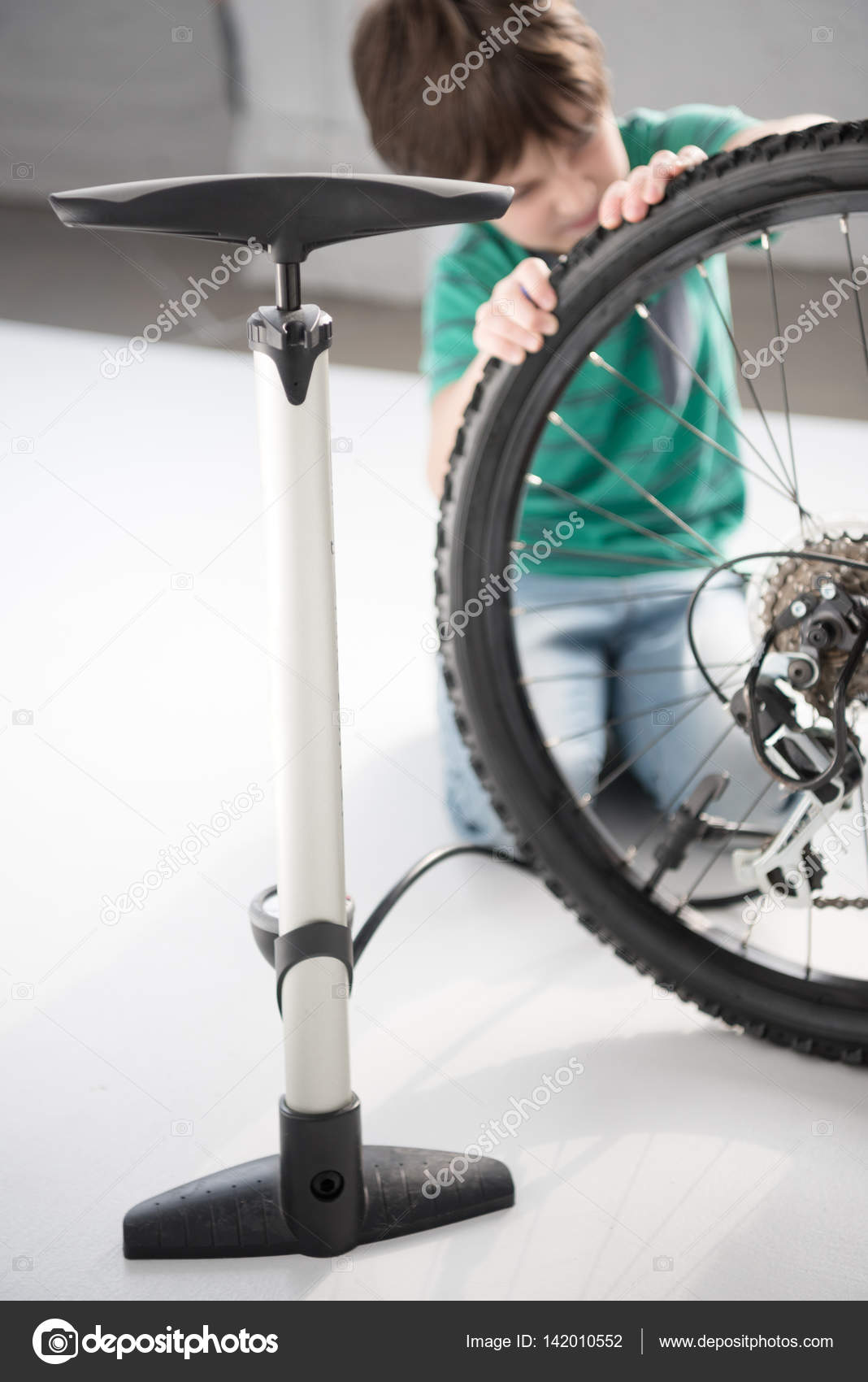 Boy inflating bicycle tire — Stock Photo © ArturVerkhovetskiy 142010552