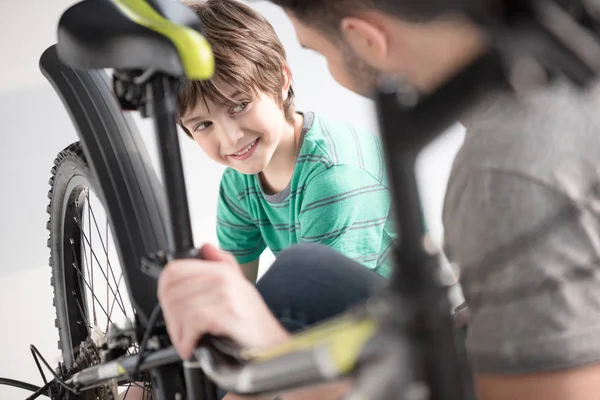 Father and son checking bicycle — Stock Photo, Image