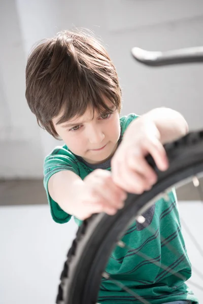 Junge überprüft Fahrradreifen — Stockfoto
