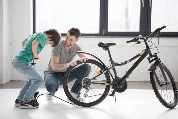 Father and son inflating bicycle tire