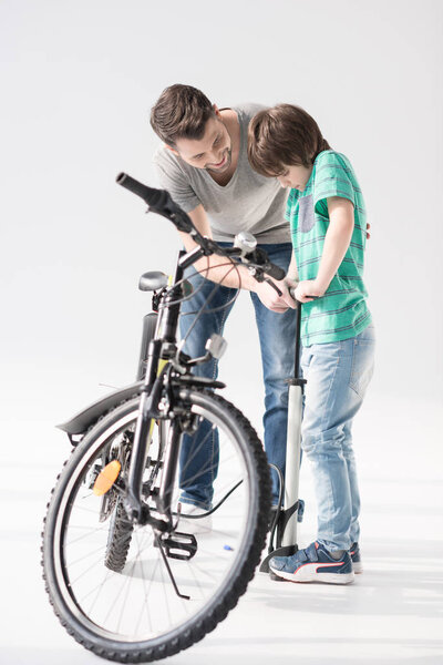 Father and son inflating bicycle tire