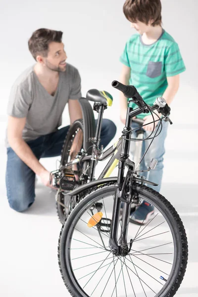 Vader en zoon oppompen fiets moe — Gratis stockfoto