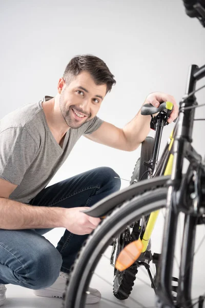 Hombre chequeando bicicleta — Foto de stock gratis