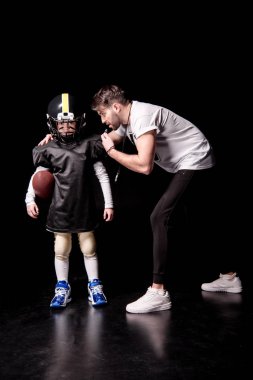 Boy playing football with trainer clipart