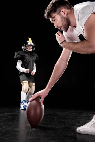 Boy playing football with trainer — Stock Photo, Image